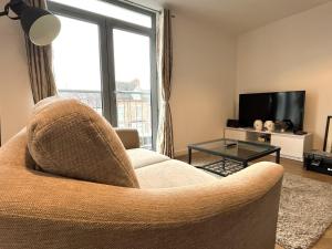 a living room with a chair and a television at Central Darlington 2 Bed Flat #8 in Darlington