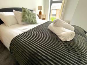 a bedroom with a bed with two towels on it at Central Darlington 2 Bed Flat #8 in Darlington