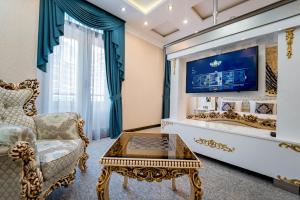 a living room with a couch and a table and a tv at Hotel Aqua Liberty in Tbilisi City