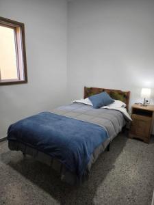 a bedroom with a bed with a blue blanket and a desk at Casa María in Santa Cruz de Tenerife