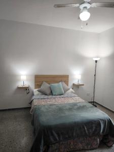 ein Schlafzimmer mit einem Bett mit zwei Lampen und einem Deckenventilator in der Unterkunft Casa María in Santa Cruz de Tenerife