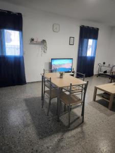 Zimmer mit einem Tisch und Stühlen sowie einem TV in der Unterkunft Casa María in Santa Cruz de Tenerife