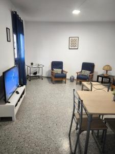 ein Wohnzimmer mit einem Flachbild-TV und Stühlen in der Unterkunft Casa María in Santa Cruz de Tenerife