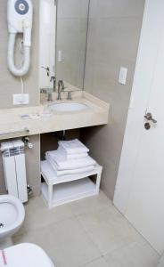 a bathroom with a sink and a toilet and a mirror at Le Batiment Apartmentos in Buenos Aires