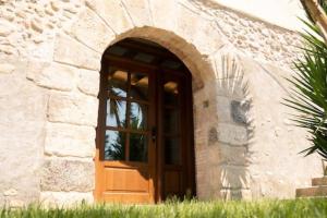 una puerta en un edificio de piedra con una ventana en Can Óscar Rural Casa con piscina y barbacoa ideal para famílias, en Mediona