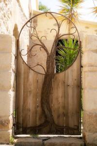 Una puerta de metal con un árbol. en Can Óscar Rural Casa con piscina y barbacoa ideal para famílias en Mediona