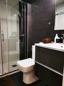 a bathroom with a toilet and a glass shower at Apartment Ruby in Lloret de Mar