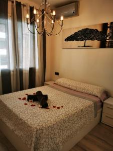 a stuffed dog laying on a bed with red roses at Apartment Ruby in Lloret de Mar