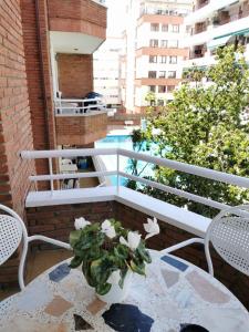 un tavolo con un vaso di fiori sul balcone di Apartment Ruby a Lloret de Mar