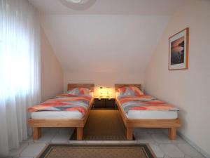 two twin beds in a small room with a window at Holiday apartment Kettler in Sassenberg
