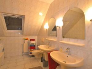 a bathroom with two sinks and a toilet and a mirror at Holiday apartment Kettler in Sassenberg
