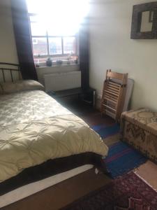 um quarto com uma cama e uma janela em Guinness Court Shared Apartment em Londres