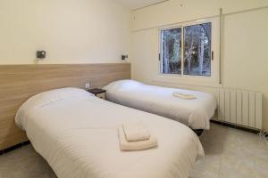 2 letti in una camera con finestra di Les Tonyines 67 Apartamento con vistas y terraza a Llança