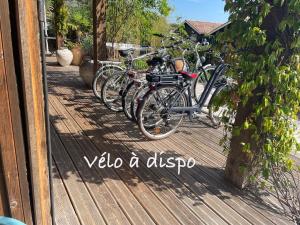 eine Gruppe von Fahrrädern, die auf einer Holzveranda geparkt sind in der Unterkunft Chambre d'Hôtes - Village Petit Piquey in Cap-Ferret