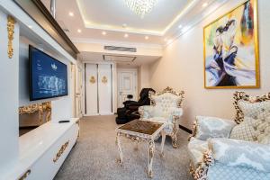 uma sala de estar com cadeiras e uma televisão de ecrã plano em Hotel Aqua Liberty em Tbilisi