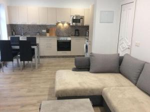 sala de estar con sofá y cocina en Holiday apartment garden apartment en La Asomada