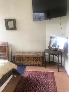 um quarto com uma cama e uma mesa com uma televisão em Guinness Court Shared Apartment em Londres