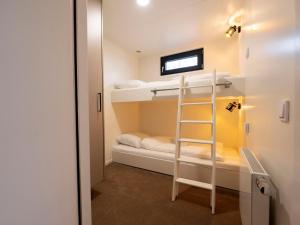 a room with two bunk beds and a ladder at Houseboat in Offingawier with Sea View in Offingawier
