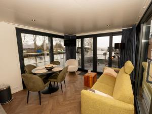 a living room with a couch and a table at Houseboat in Offingawier with Sea View in Offingawier