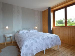 ein Schlafzimmer mit einem Bett mit einer weißen Bettdecke und einem Fenster in der Unterkunft Nice holiday home with sauna near Malmedy in Malmedy