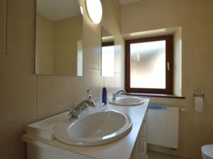 a bathroom with two sinks and a mirror and a window at Spacious Home, Malmedy in Malmedy +32 photos