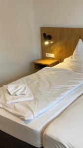 a bed with a white towel sitting on top of it at Ferienwohnungen zum Stern in Bühlertann
