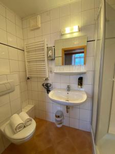 a white bathroom with a sink and a toilet at Hotel Hieronimi in Cochem