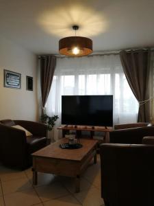 un soggiorno con TV a schermo piatto e tavolo di Médina maison 4 chambres 100m2 a Beuvrages