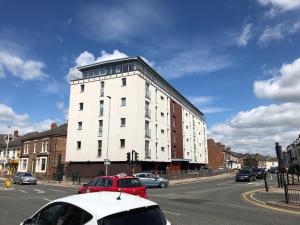 a white building with cars parked on a city street at Central Darlington 2 Bed Flat #8 in Darlington