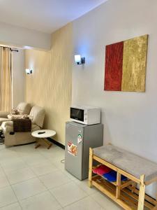 - un salon avec un réfrigérateur et un canapé dans l'établissement Rorot 1 bedroom Modern fully furnished space in Annex Eldoret with free wifi, à Eldoret