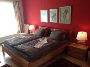 1 dormitorio con 1 cama con pared roja en Förster Appartements, en Bad Vöslau