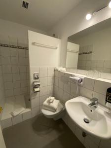 a bathroom with a sink and a toilet and a mirror at Hotel Hieronimi in Cochem +22 photos