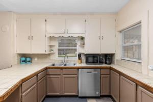 a kitchen with white cabinets and a sink at Charming 4BR Westside Home in Beer City USA in Grand Rapids