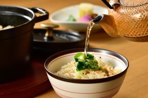 a teapot pouring food into a bowl of rice at Hinatamikan in Nakanojo