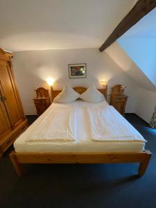 a bedroom with a bed with white sheets and pillows at Hotel Hieronimi in Cochem