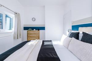 a bedroom with a black and white bed and a dresser at Agbrigg Park by Nordstay in Wakefield