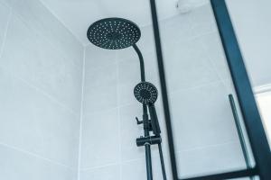 a shower with a shower head in a bathroom at Agbrigg Park by Nordstay in Wakefield