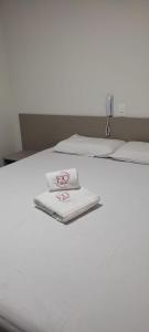 - un lit blanc avec 2 serviettes blanches dans l'établissement ESPETO DE OURO HOTEL, à Ouricuri