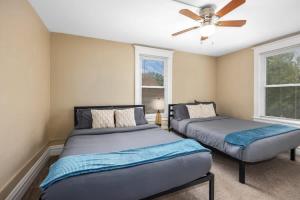 a bedroom with two beds and a ceiling fan at Charming 4BR Westside Home in Beer City USA in Grand Rapids