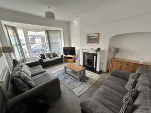 sala de estar con sofá y chimenea en Sandy Lodge en Hornsea