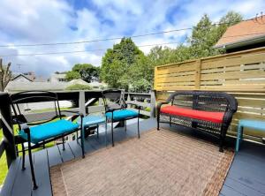 a patio with chairs and benches on a deck at Charming 4BR Westside Home in Beer City USA in Grand Rapids