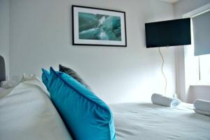 a white bed with blue pillows in a bedroom at Honest Airport University House 1 with FREE PARKING and FAST WIFI in Southampton