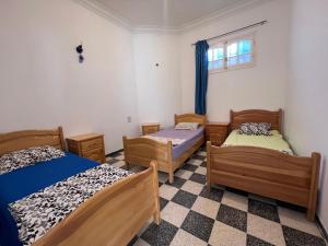 pokój z 3 łóżkami i oknem w obiekcie App s+2 RDC w mieście Tauzar