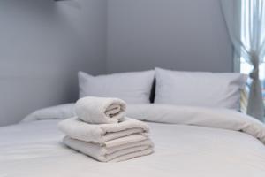 una pila de toallas sentadas en una cama en Park Wodny Cosy Studio, en Cracovia