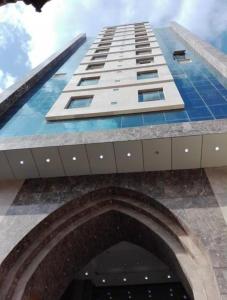 a tall building with an arch in front of it at Arfalon Hotel and Tourism in Makkah