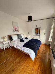 um quarto com uma cama grande e piso em madeira em Sonas Apartment em Galway