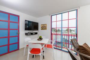a dining room with a table and chairs and windows at Full Apartamento Privado 202 Guatapé in Guatapé