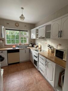 a kitchen with white cabinets and a counter top at Sonas Seaside Apartment in Galway