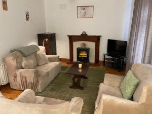 a living room with two couches and a fireplace at Sonas Seaside Apartment in Galway