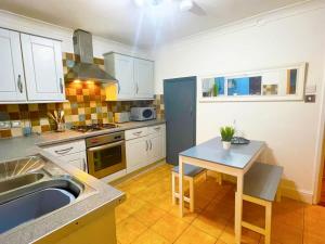 a kitchen with a sink and a table in it at Cosy home with FREE PARKING and fast internet in Portsmouth